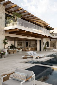 an outdoor swimming pool with lounge chairs and potted plants