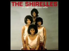 the supremes pose for a portrait in their red skirts and white tops, smiling at the camera