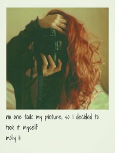 a woman with long red hair holding a camera