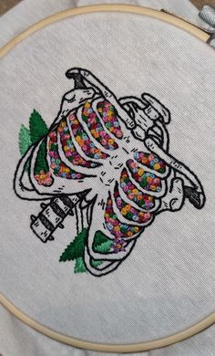 a cross stitched image of a skeleton with sprinkles on it's chest