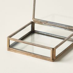 an empty glass box sitting on top of a white table