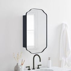 a bathroom sink with a mirror above it and a towel hanging on the wall next to it