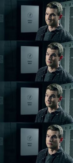 the man is standing in front of some lockers with his eyes closed and one eye open