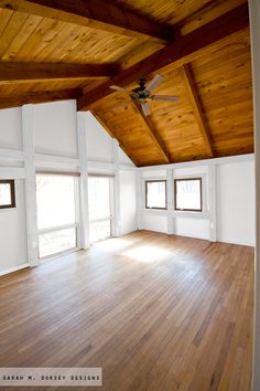 an empty room with wooden floors and ceiling fan