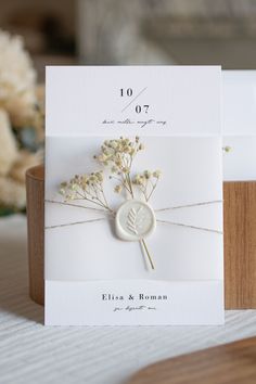 a wedding card with dried flowers on it