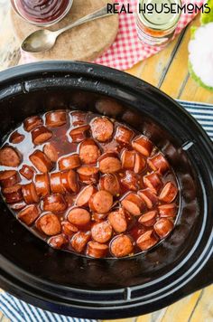 a crock pot filled with hot dogs on top of a table