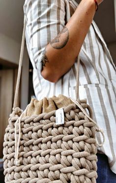 a person holding a woven bag with a tag on it