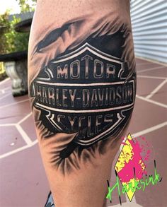 a close up of a person's leg with a motorcycle tattoo on it and the words harley davidson cycles