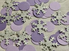 purple and silver paper snowflakes on a table