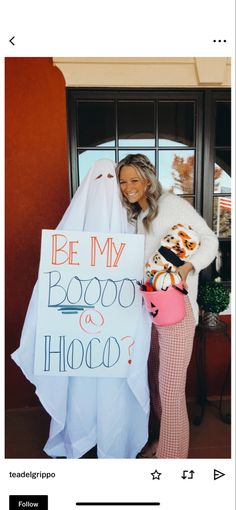 a woman holding a sign that says be my booboo and holopop