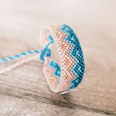 a close up of a bracelet on top of a wooden table next to a string