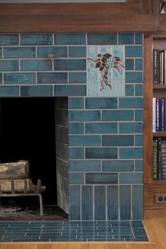 a blue brick fireplace in a living room with bookshelves and a wooden bench