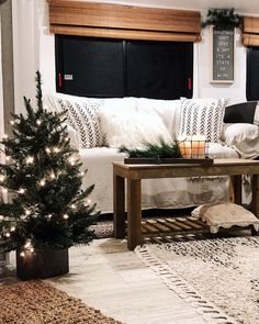 a living room decorated for christmas with lights and decorations on the coffee table in front of the couch