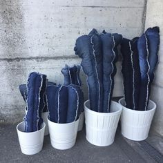 five white buckets with blue denim cactus plants in them