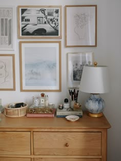 a wooden dresser topped with lots of framed pictures