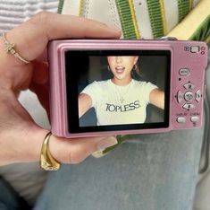 a person holding up a pink camera to take a picture with the image on it