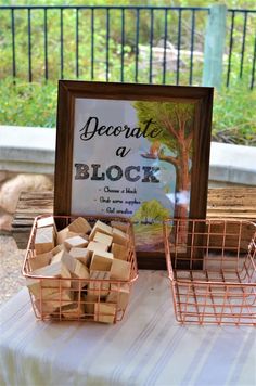 a table topped with baskets filled with blocks of wood next to a sign that reads, record a block