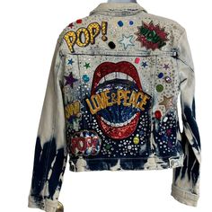 a denim jacket with the words pop on it and an image of a tongue sticking out