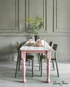 a table with two chairs and a vase filled with flowers sitting on top of it