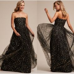 Step Into A Starlit Dream With This Joanna August Strapless Maxi Dress. The Ethereal Gold Stars Shimmer Against The Black Tulle, Creating A Celestial Ballet With Every Movement. Crafted Meticulously, The Dress Ensures You Radiate Elegance At Any Formal Event. Let Your Inner Star Shine Brightly. Color: Black / Gold Strapless Design Black Tulle With Gold Star Details Side Zipper Closure Maxi Length Fully Lined Approximate Measurements Taken While Lying Flat: Length: 56" Waist 13.5" Pit To Pit: 15" Gown Gold, Bhldn Dress, Tulle Maxi Dress, Strapless Evening Dress, Black Tulle, Black Tie Wedding, Strapless Gown, Strapless Maxi Dress, 80 Dress