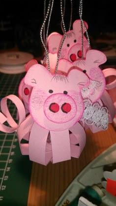 some pink items are hanging from chains on a table