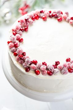 a white cake with cranberry frosting and sprinkles on top