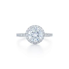 a diamond engagement ring with an oval center surrounded by round brilliant pave set diamonds