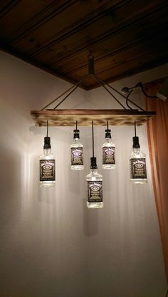 five mason jar lights hanging from a wooden beam