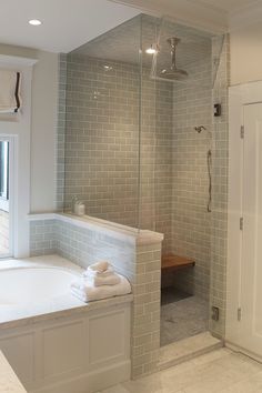 a bathroom with a walk in shower next to a bath tub