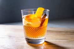 a glass filled with an orange peel and ice