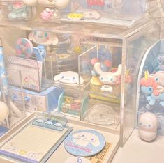 a display case filled with lots of toys and items on top of a table in front of a window