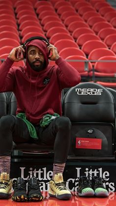 a man sitting on top of a bench with headphones in front of his ears