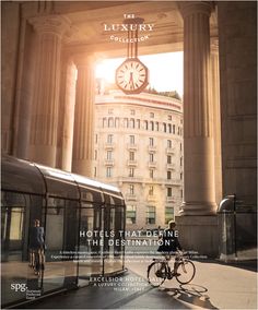 a person riding a bike in front of a tall building with columns and a clock on it