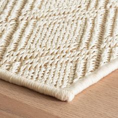 a close up of a rug on a wooden floor with wood floors and white carpet