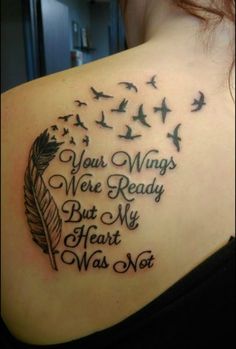 the back of a woman's shoulder with birds flying around her and an inscription on it