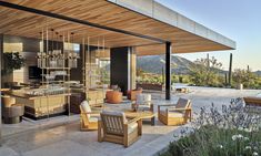 an outdoor kitchen and dining area with wooden furniture