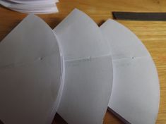 three pieces of white paper sitting on top of a wooden table