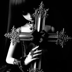 black and white photograph of a woman holding a cross with her hands on the cross