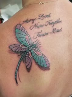 a woman's back with a dragonfly tattoo on it