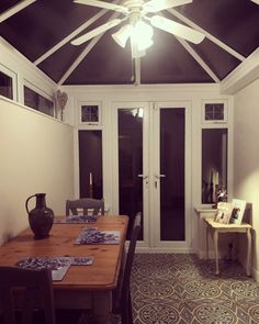 a dining room table with chairs and a ceiling fan