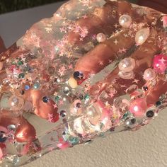 a close up of a person's hand holding a piece of glass with stars and pearls on it