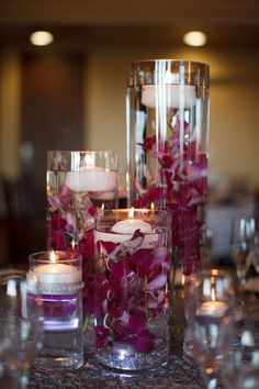 candles and flowers in glass vases on a table