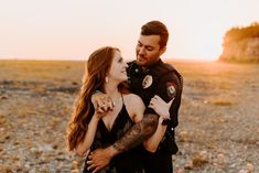 a man and woman hugging each other in the desert