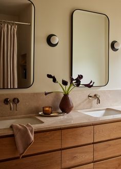 a bathroom with two sinks and mirrors above them