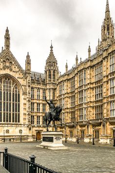 a statue of a man riding a horse in front of a building with tall towers