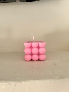 a pink candle sitting on top of a counter