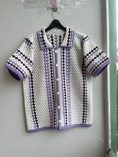 a crocheted jacket hanging on a wall