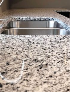 a granite counter top in a kitchen with stainless steel sink