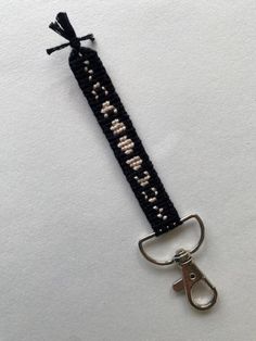 a pair of scissors is attached to a keychain that has beads on it