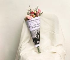 a bouquet of flowers laying on top of a white sheet next to a wall with an advertisement